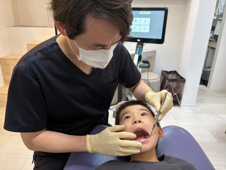 チェアで、渡邉先生がお子さまのお口を診ている様子